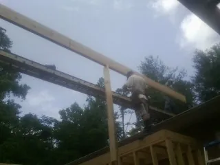 Carpenter setting a ridge beam over a new addition frame — Ice Dam Removal by Roofing Brothers in Bridgewater
